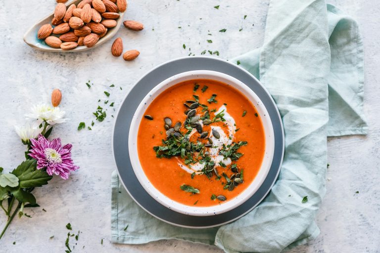 Bowl of tomato soup with herbs and almonds