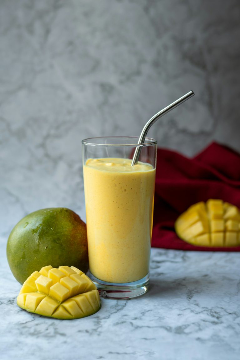 Mango smoothie in a glass with fresh mango