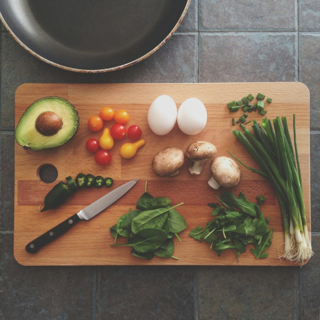 Fresh ingredients on a chopping board with eggs, avocado and tomatoes
