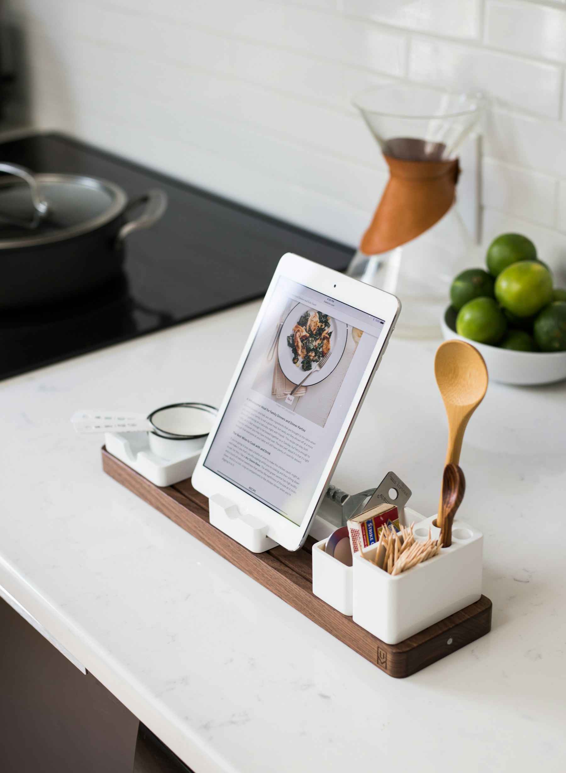 Tablet showing a recipe on a kitchen counter next to limes