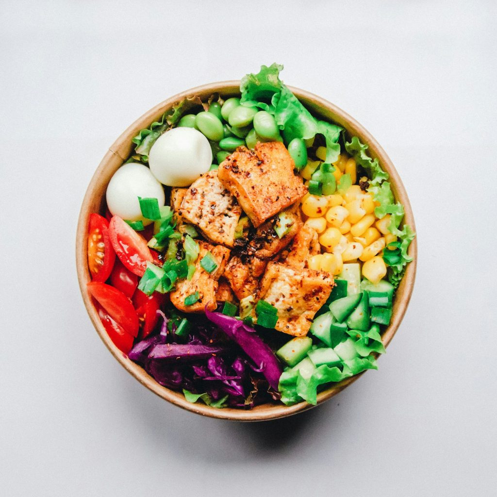 Chicken burrito bowl with corn, tomatoes, cabbage and greens