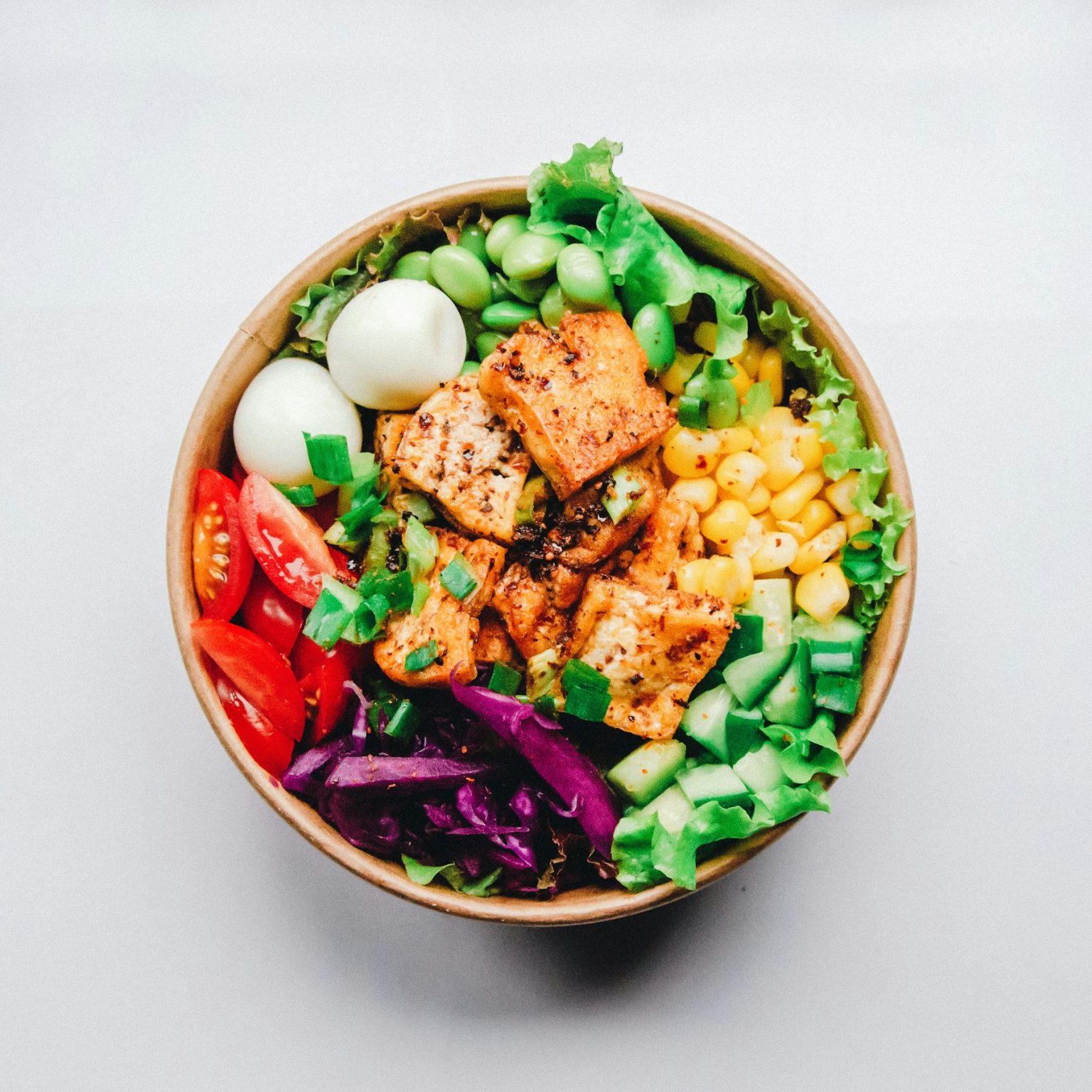 Chicken burrito bowl with corn, tomatoes, cabbage and greens