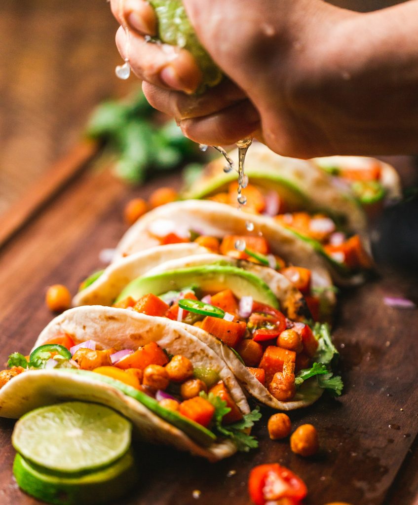 Tacos with seasoned filling, fresh vegetables and herbs