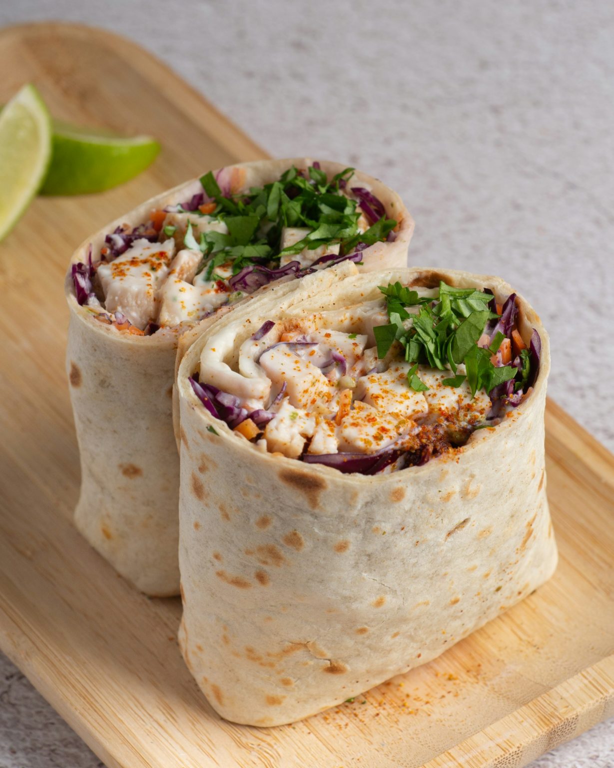 Chicken salad wraps cut in half, filled with crunchy vegetables